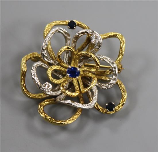 A yellow and white metal open work flower head brooch, set with sapphires and diamonds, 21.6 grams.